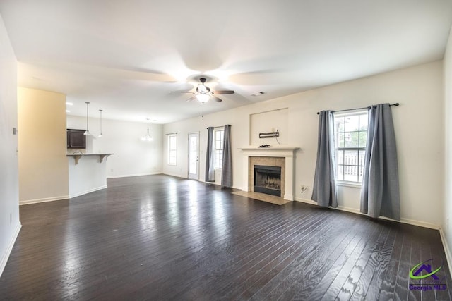 unfurnished living room featuring ceiling fan and dark hardwood / wood-style floors