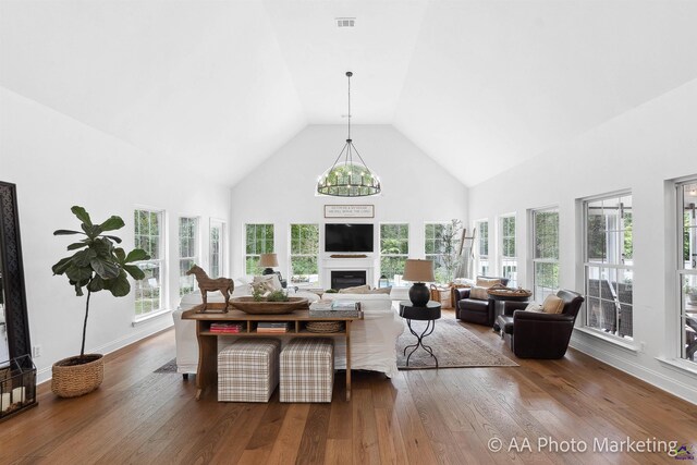 living room featuring a chandelier, dark hardwood / wood-style flooring, and high vaulted ceiling