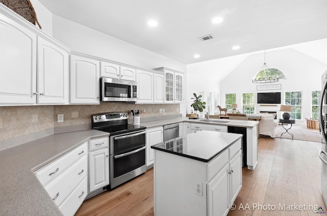 kitchen with tasteful backsplash, white cabinetry, a kitchen island, and appliances with stainless steel finishes