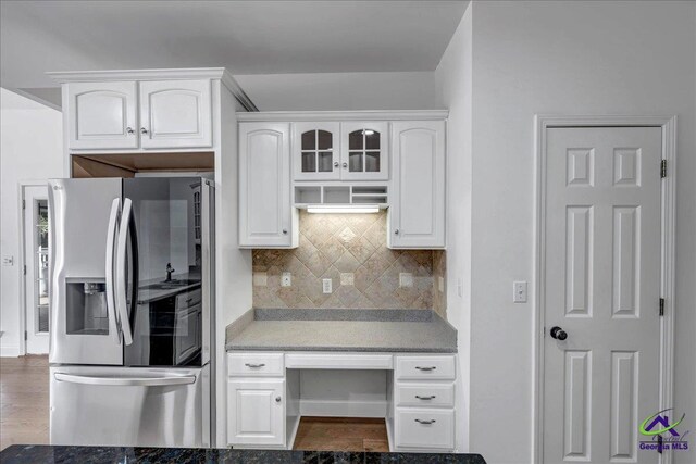 kitchen with white cabinets, stainless steel fridge, and decorative backsplash