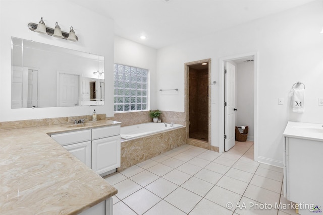 bathroom featuring shower with separate bathtub, vanity, and tile patterned floors