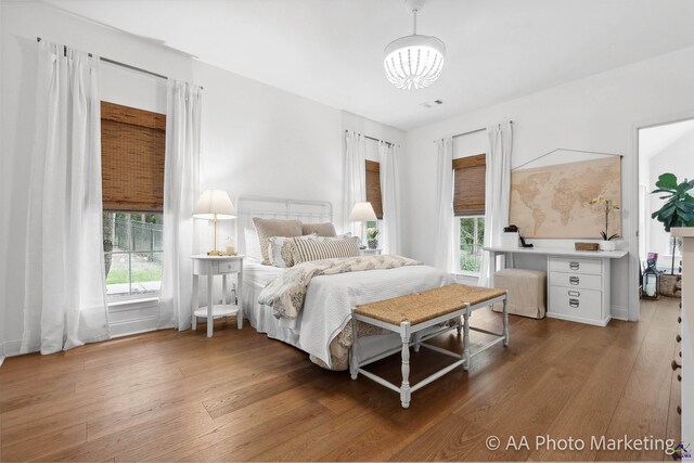 bedroom with hardwood / wood-style floors and multiple windows