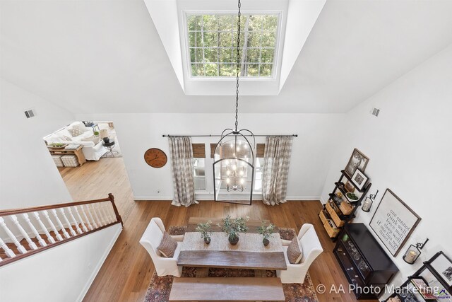 dining room featuring a chandelier, lofted ceiling, and wood-type flooring