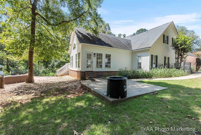 back of property featuring a lawn and a patio area