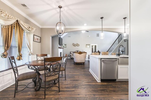 dining room featuring a notable chandelier, sink, dark wood-type flooring, and crown molding