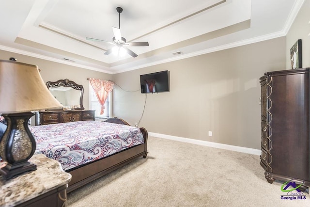 bedroom with ceiling fan, a raised ceiling, light colored carpet, and ornamental molding