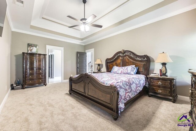 carpeted bedroom featuring a tray ceiling, ceiling fan, and ornamental molding