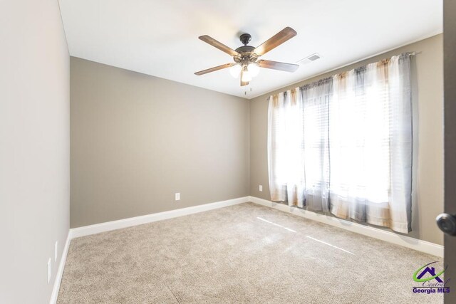 carpeted spare room with ceiling fan and plenty of natural light