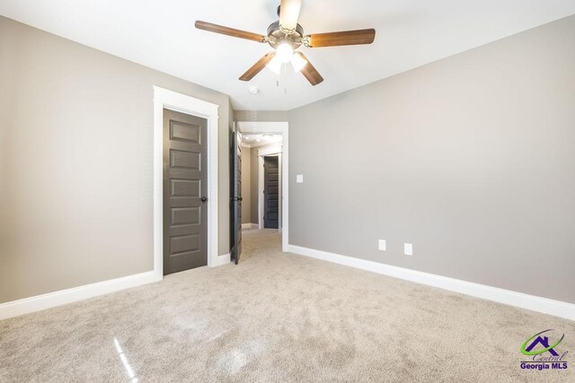 unfurnished bedroom featuring light carpet and ceiling fan