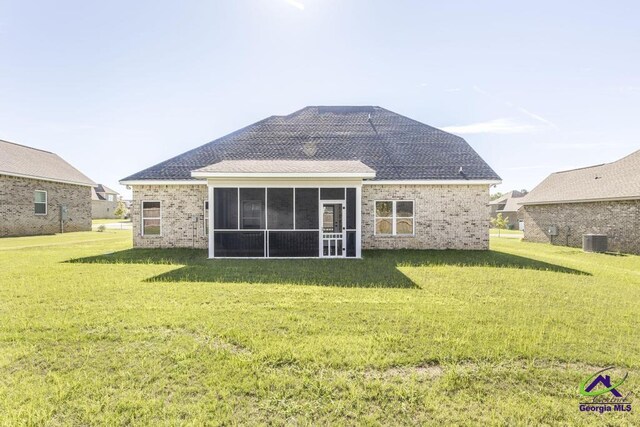 back of house with a sunroom, a yard, and cooling unit