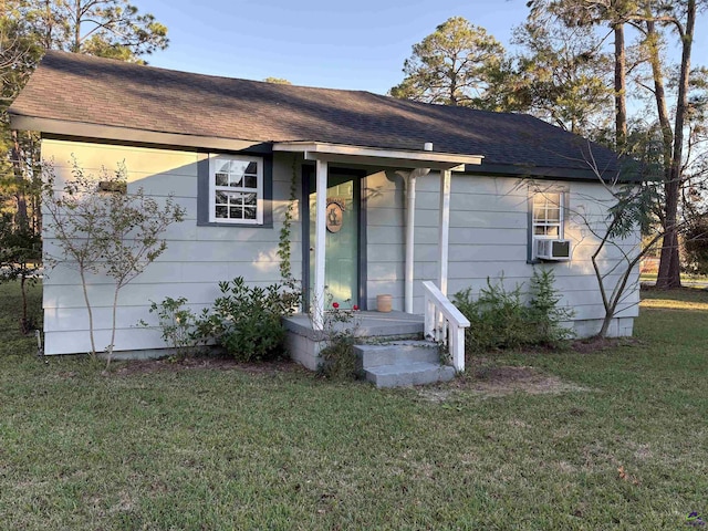 ranch-style house featuring cooling unit and a front lawn