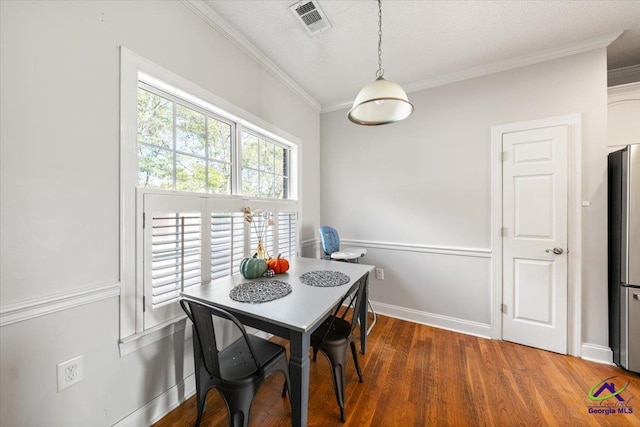 dining space with dark wood-type flooring and ornamental molding