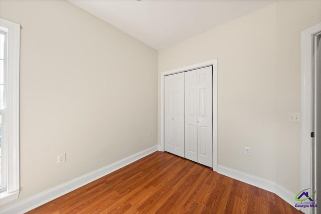 unfurnished bedroom with wood-type flooring and a closet