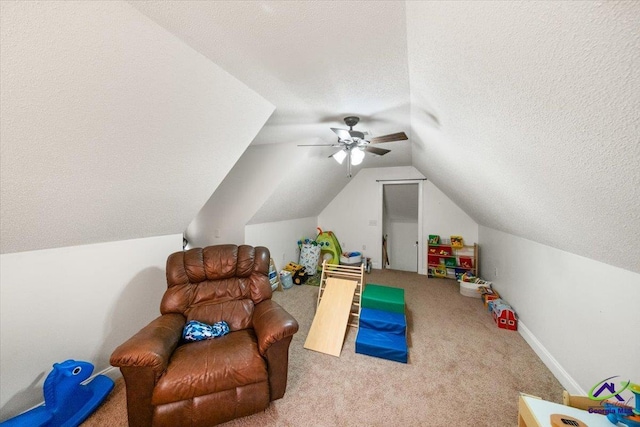 rec room featuring ceiling fan, lofted ceiling, a textured ceiling, and carpet floors