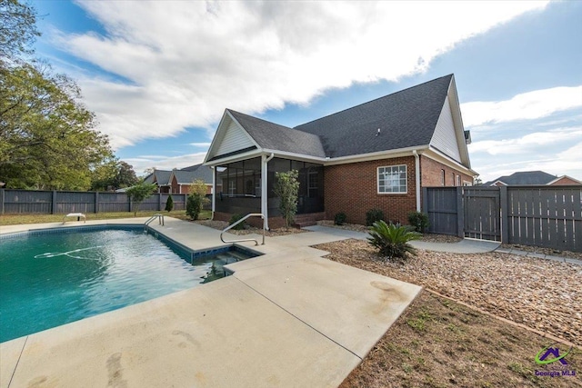 view of swimming pool with a sunroom and a patio