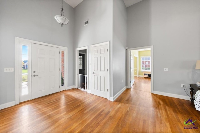 foyer with hardwood / wood-style floors and a towering ceiling