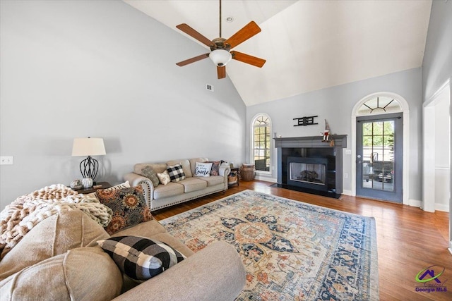 living room with ceiling fan, high vaulted ceiling, and wood-type flooring