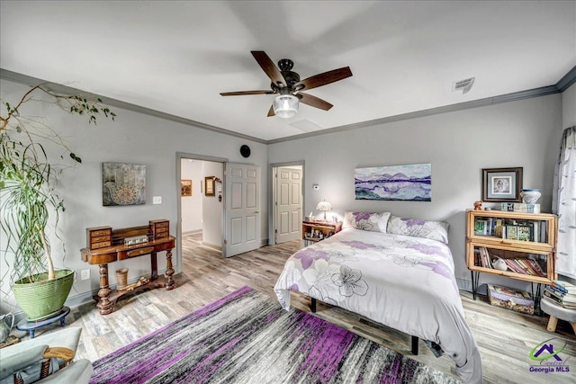 bedroom with ceiling fan, crown molding, and light hardwood / wood-style floors