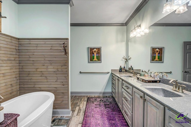 bathroom featuring vanity, wood-type flooring, ornamental molding, and a bath