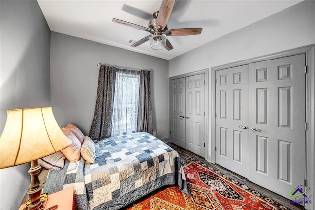 bedroom with ceiling fan and two closets