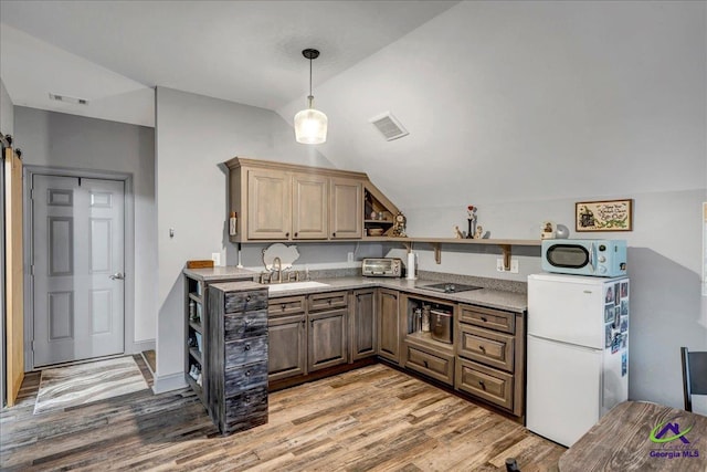 kitchen featuring sink, hanging light fixtures, wood-type flooring, lofted ceiling, and white appliances