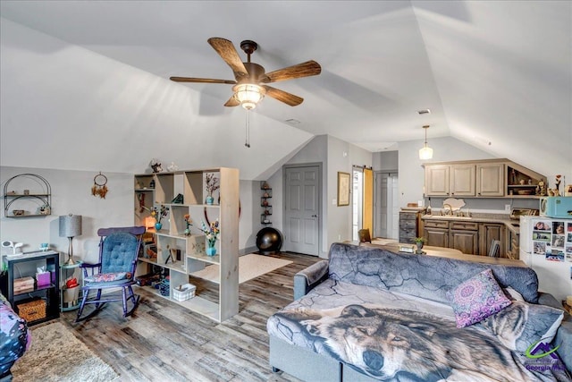 living room with ceiling fan, wood-type flooring, and lofted ceiling