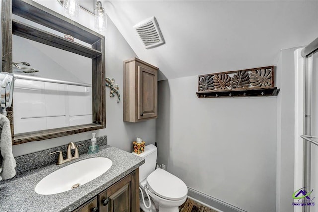 bathroom with vanity, toilet, and lofted ceiling