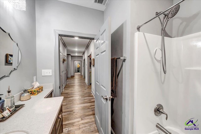 bathroom with shower / bathing tub combination, vanity, and hardwood / wood-style floors