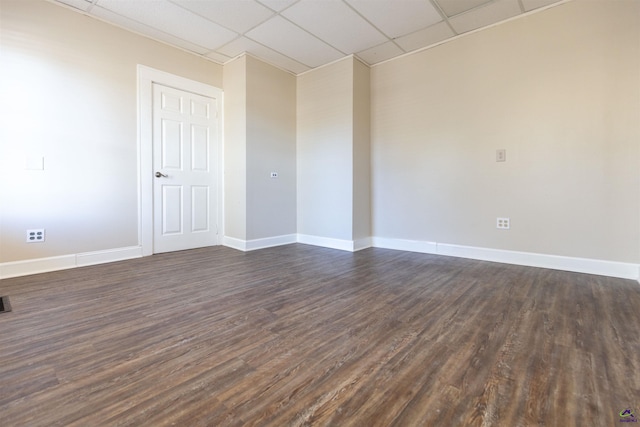 empty room featuring dark hardwood / wood-style flooring and a drop ceiling