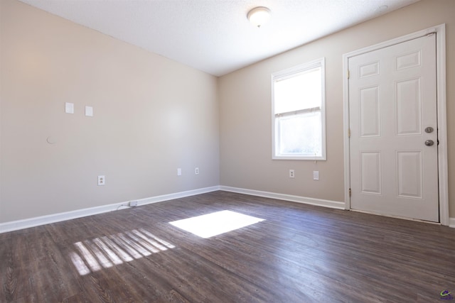 spare room with dark wood-type flooring