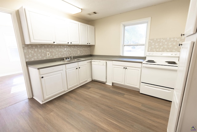 kitchen featuring tasteful backsplash, white appliances, sink, hardwood / wood-style floors, and white cabinetry