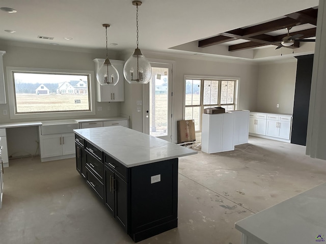 kitchen featuring coffered ceiling, pendant lighting, white cabinets, and a kitchen island