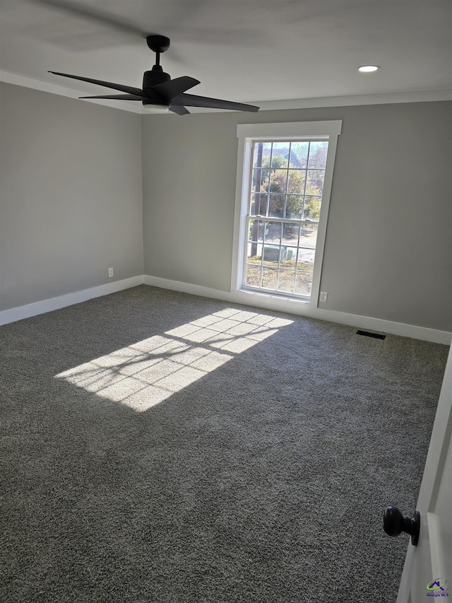 carpeted spare room with ceiling fan and ornamental molding