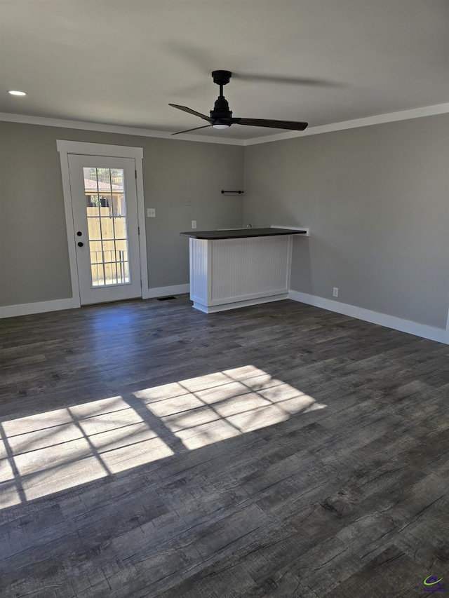 unfurnished living room with ceiling fan, dark hardwood / wood-style flooring, and crown molding