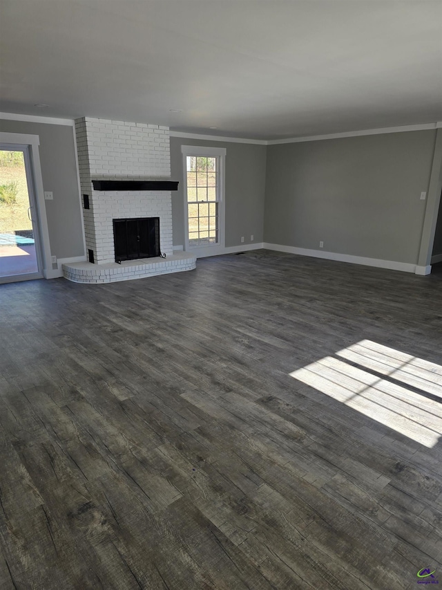 unfurnished living room featuring a fireplace, dark wood-type flooring, and ornamental molding