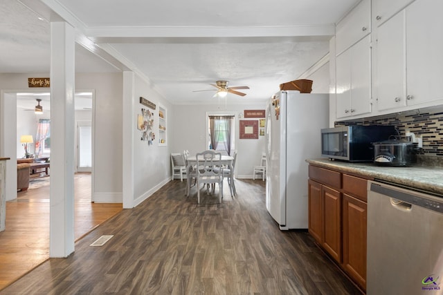 kitchen with white cabinets, backsplash, stainless steel appliances, and dark wood-type flooring