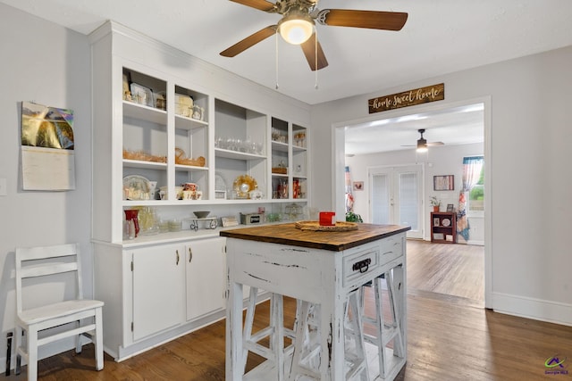 kitchen featuring french doors, butcher block countertops, white cabinetry, and dark wood-type flooring