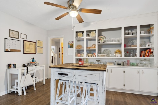 interior space with butcher block countertops, dark hardwood / wood-style floors, ceiling fan, and white cabinetry