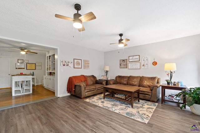 living room with ceiling fan and wood-type flooring