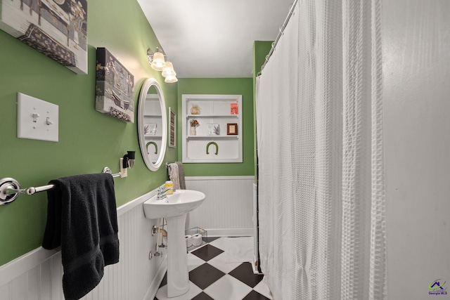 bathroom with built in shelves and a shower with curtain