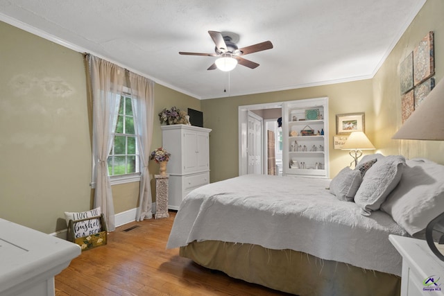 bedroom featuring light hardwood / wood-style flooring, ceiling fan, and ornamental molding