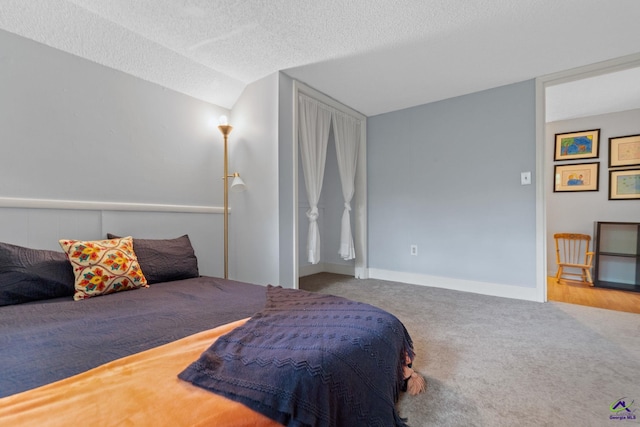 carpeted bedroom featuring lofted ceiling and a textured ceiling