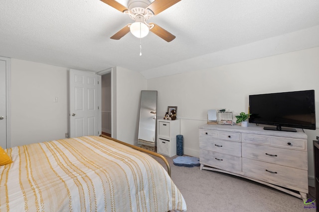 carpeted bedroom with a textured ceiling, ceiling fan, and lofted ceiling