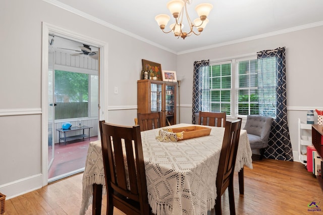 dining room with a chandelier, light wood-type flooring, and ornamental molding