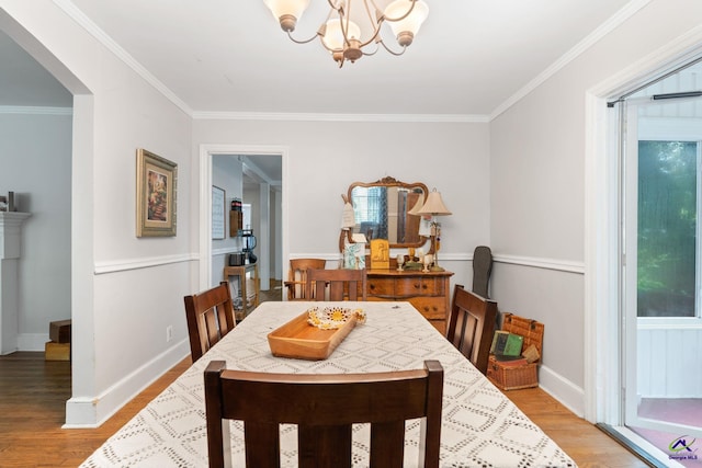 dining space with light hardwood / wood-style floors, a notable chandelier, and ornamental molding