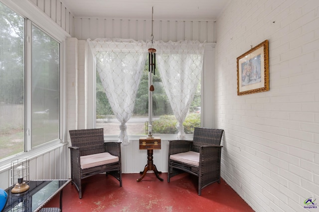 sitting room with a healthy amount of sunlight and brick wall