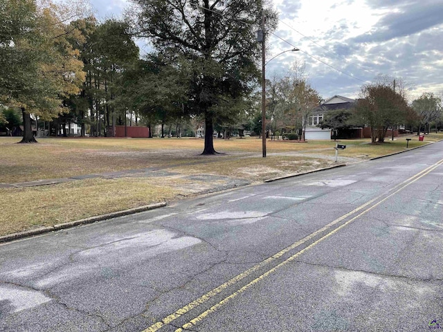 view of road featuring curbs and street lighting