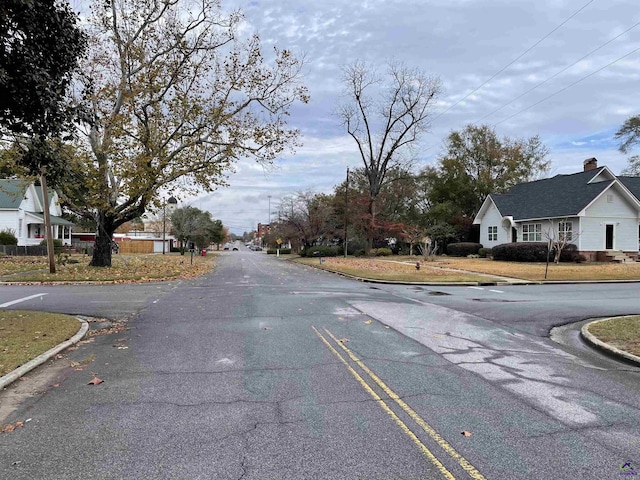 view of street with a residential view and curbs