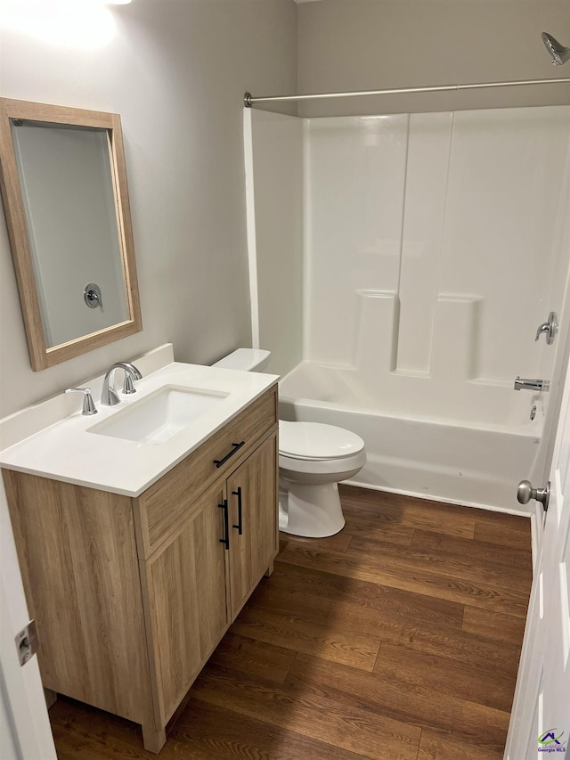 full bathroom featuring hardwood / wood-style flooring, vanity,  shower combination, and toilet