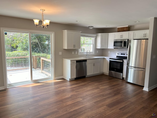 kitchen featuring pendant lighting, white cabinetry, sink, and appliances with stainless steel finishes